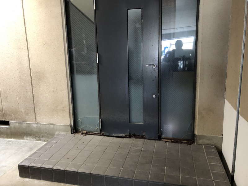 玄関ドア　施工前です。下部の鉄枠が劣化してドアや枠が下に下がっています。